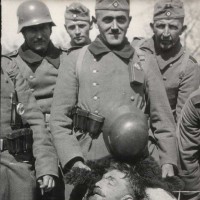 Grisly Ending. 
Soldiers of Nazi Germany proudly display their ‘prized trophy’ - the captured, killed and bloodied Commanding officer of Romuald’s unit, Major Henryk ‘Hubal’ Dobrzanski.